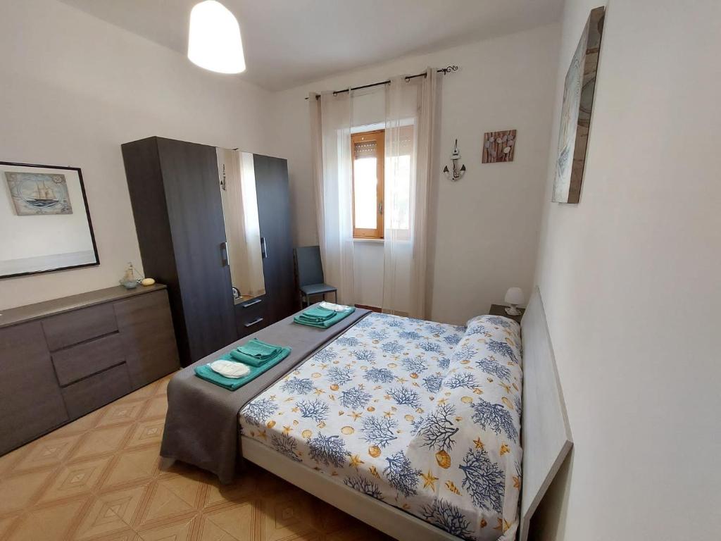 a bedroom with a bed and a dresser at Appartamento Acquamarina Torre Canne in Torre Canne