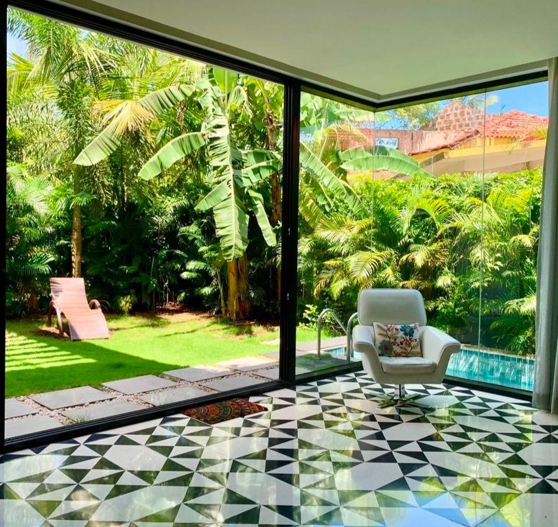 a living room with a window and a chair at Casa Mahua, Anjuna Vagator near Beach, with Pvt pool & Garden in Vagator