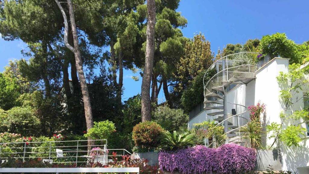 Villa Ulisse - Suites - Luxury B&B في نومانا: مبنى به مجموعة من الزهور والأشجار