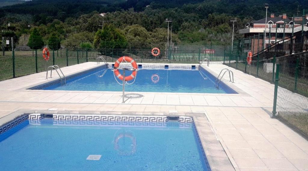 duży basen z kołem ratunkowym w obiekcie CASTRO COSTA NORTE Apartamento Jardín Garaje w mieście Castro-Urdiales