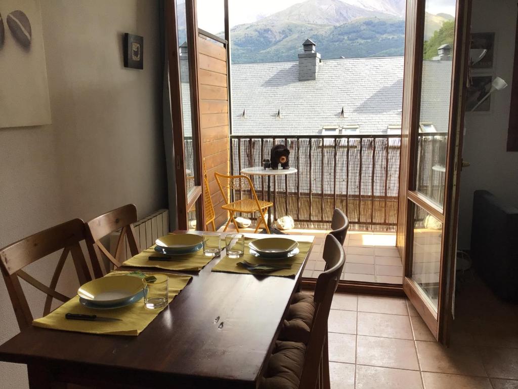 a dining room table with a view of a balcony at Paso del Onso in Escarrilla