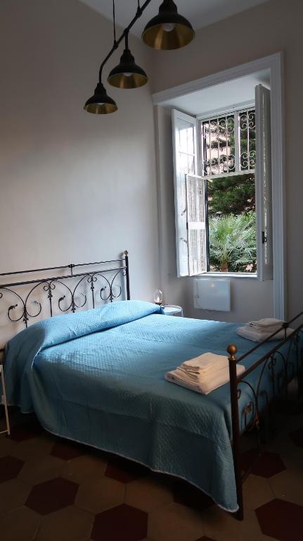 una camera con un letto blu e una finestra di La Casa di Isidoro a Napoli