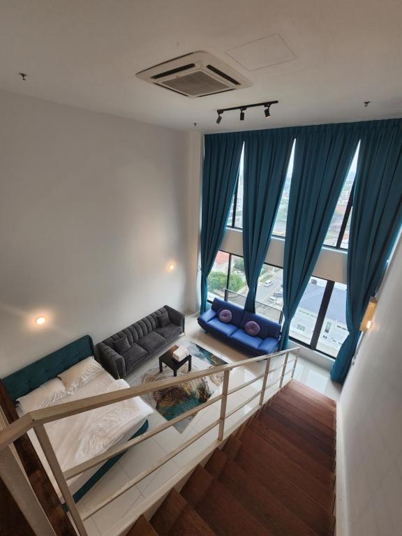 Zimmer mit einem Bett, einem Sofa und Fenstern in der Unterkunft Sunrise Gurney Premium Suite - Gurney Drive in George Town