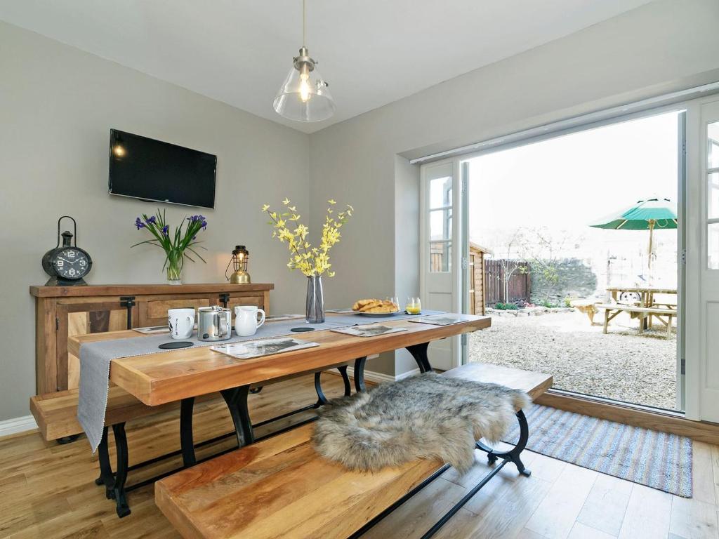 Pinfold Cottage في ريتشموند: غرفة طعام مع طاولة ونافذة كبيرة