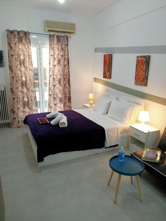 a bedroom with a large bed and a table at Cozy spot apt next to metro station . in Athens