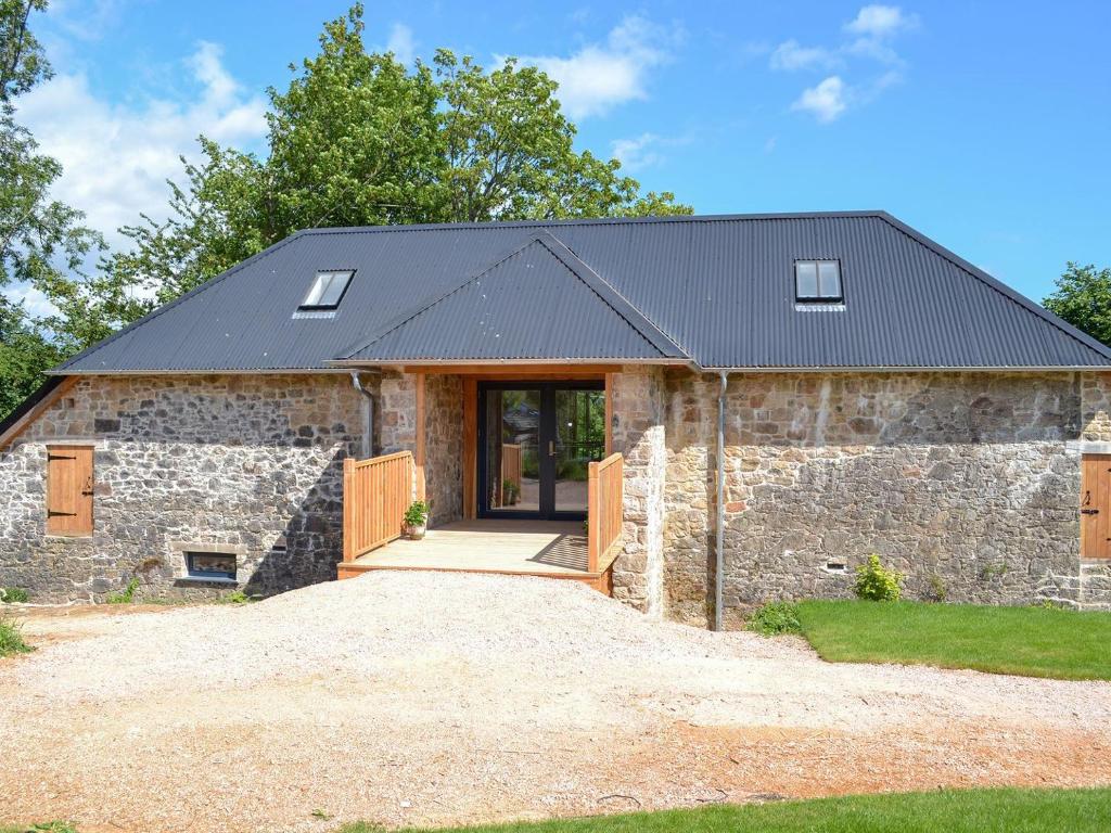 an old stone barn with a black roof at Love Barn in Darlington