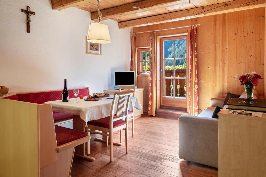 cocina y sala de estar con mesa y comedor en Apartment Birke- Fiechterhof, en Sarentino