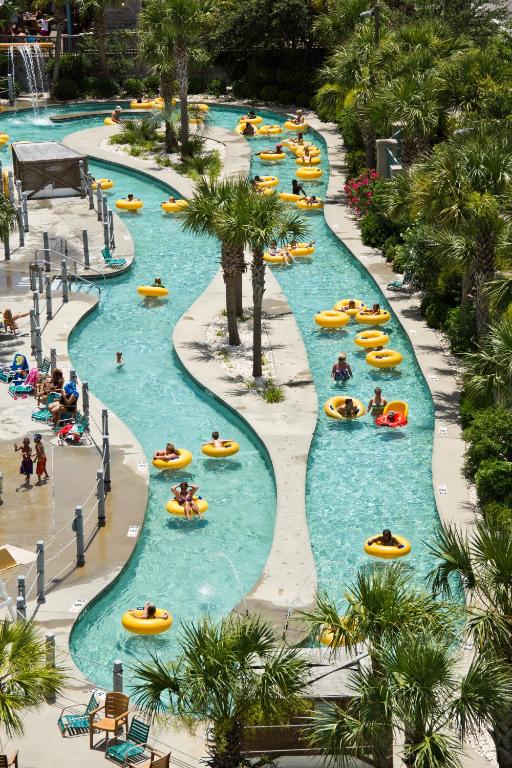 a group of people tubing down a lazy river at a resort at Sand Dunes Resort and Suites in Myrtle Beach