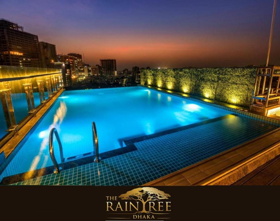 a large swimming pool on top of a building at night at The Raintree Dhaka - A Luxury collection Hotel in Dhaka