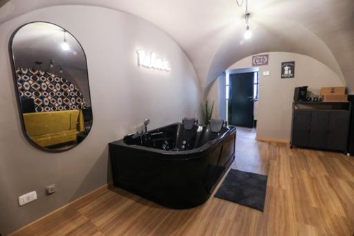 baño con bañera negra y espejo en LOFT ATENEO, en Bari