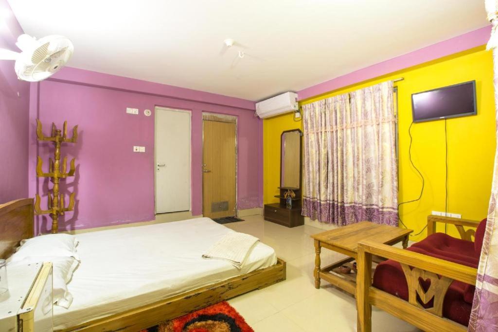 a bedroom with purple and yellow walls and a bed at Fanush Resort in Bāndarban