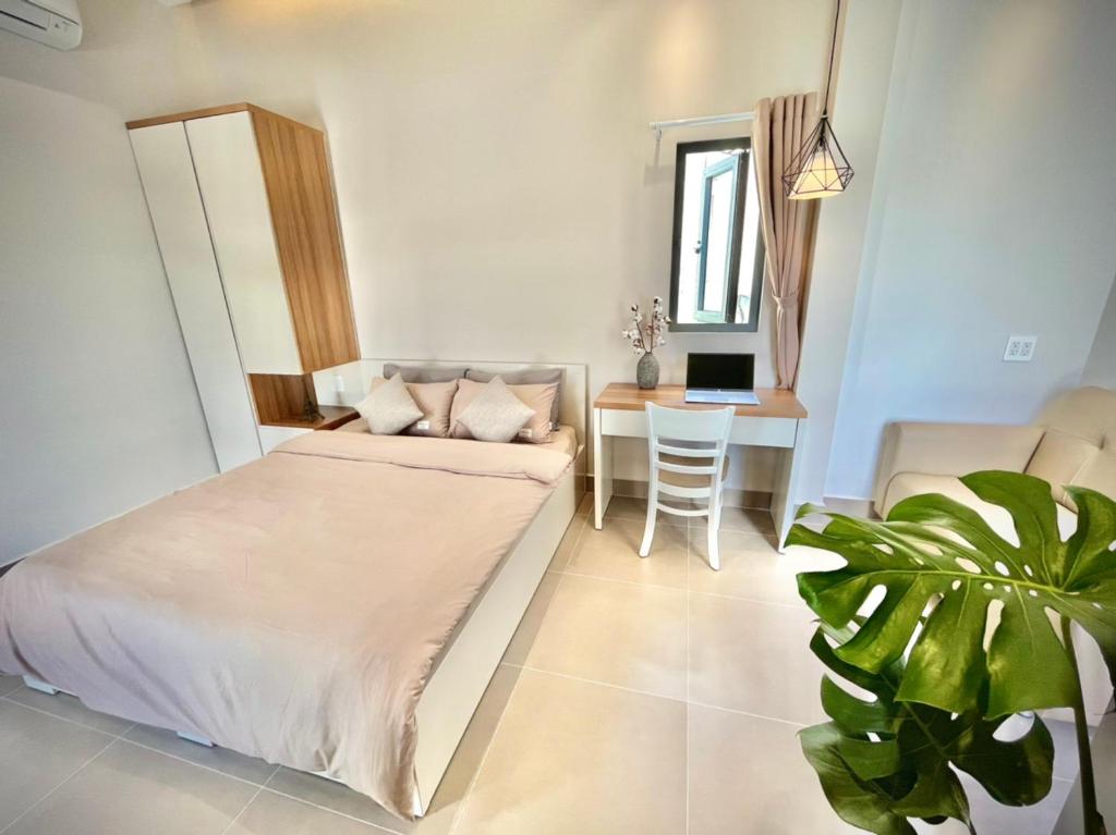 ein Schlafzimmer mit einem Bett, einem Tisch und einem Sofa in der Unterkunft MIDMOST HOUSE in Cần Thơ