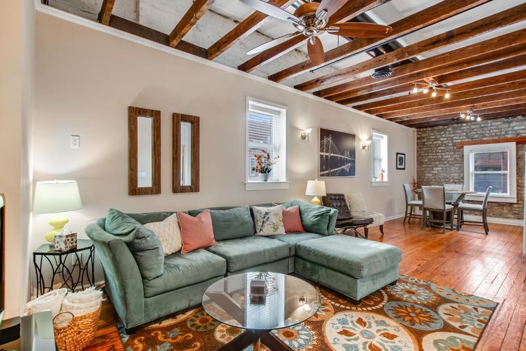 a living room with a green couch and a table at Historic City Market - Loft Off Broughton Too in Savannah