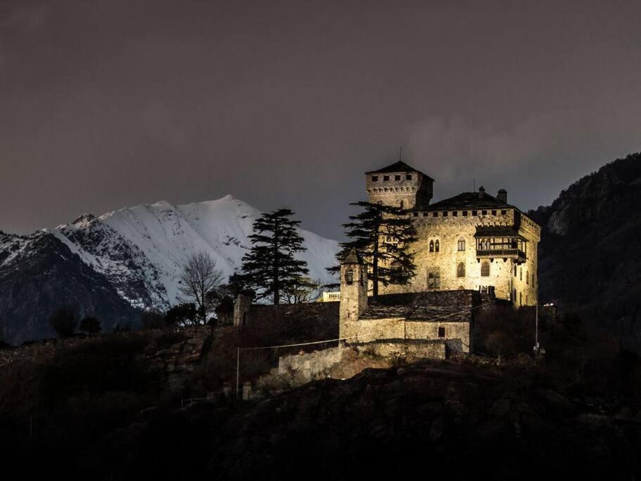 a castle on a hill with a snow covered mountain at Romantic Italian Castle at the foot of the Alps in Settimo Vittone