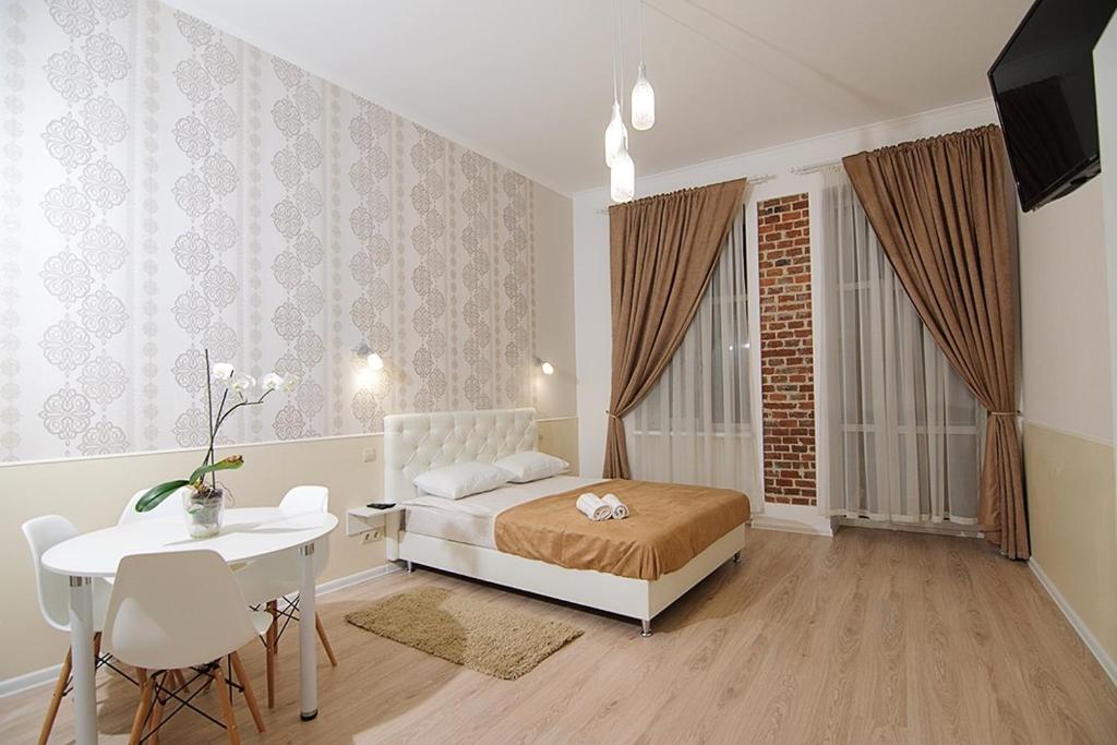 - une chambre avec un lit, une table et une fenêtre dans l'établissement Luxury Apartment near Rynok Square, à Lviv