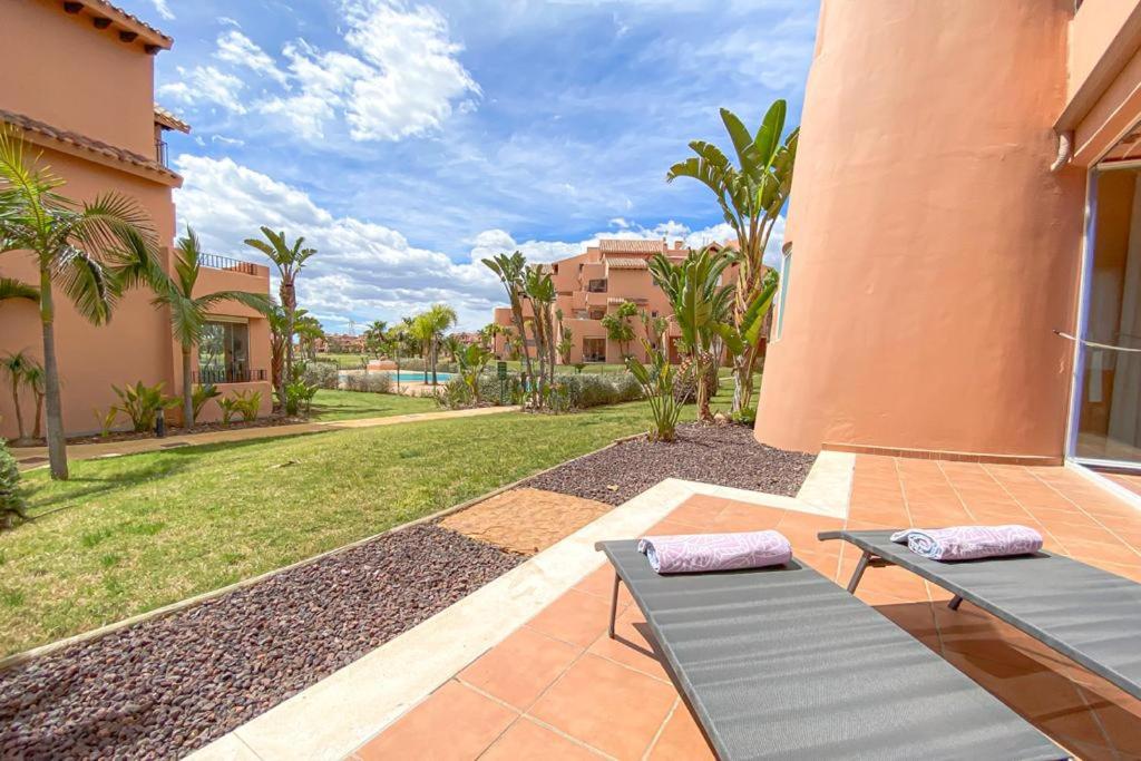 un patio con 2 tumbonas y un patio en Superb luxurious groundfloor 1 bedroom app on Mar Menor golf resort en Torre-Pacheco