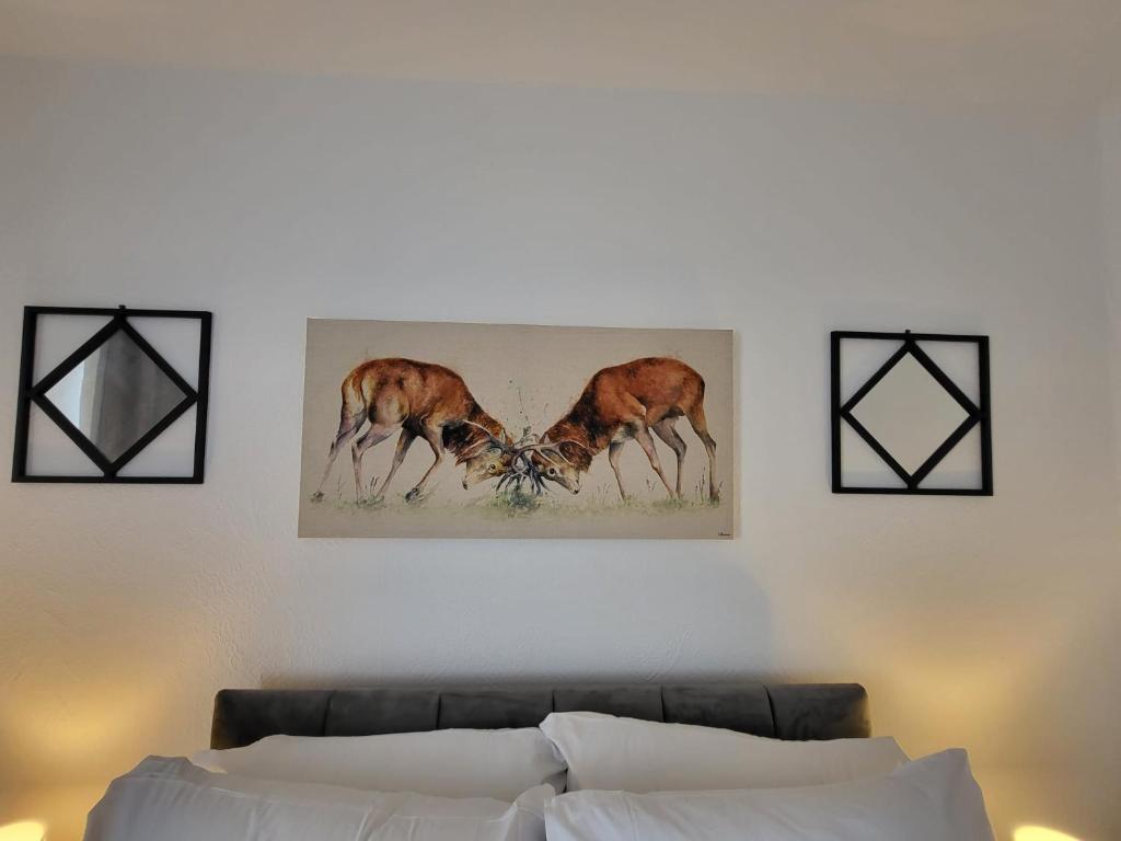 two deer painting on a wall above a couch at Emerald House in Luton