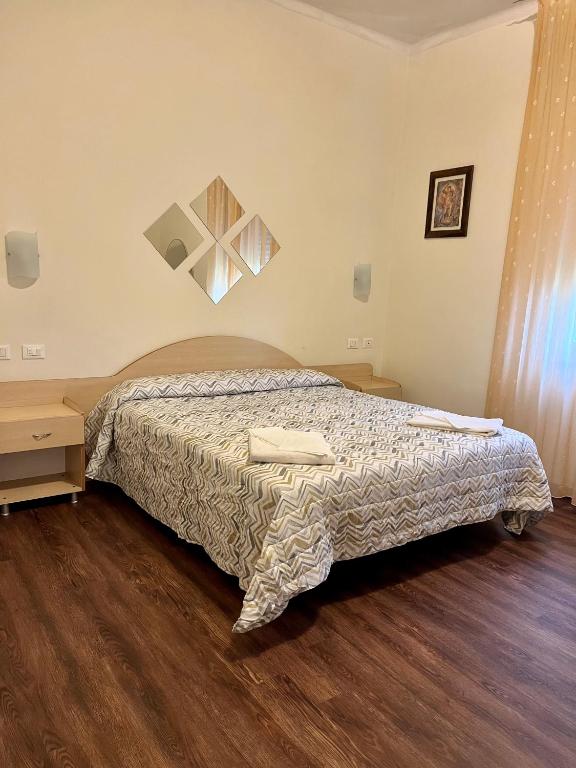 sypialnia z łóżkiem i drewnianą podłogą w obiekcie Hotel degli Dei w mieście Pianoro