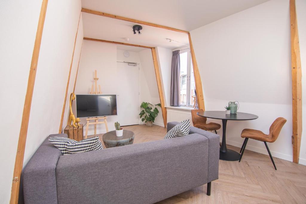 - un salon avec un canapé et une table dans l'établissement Appartement in binnenstad/centrum van Leeuwarden, à Leeuwarden