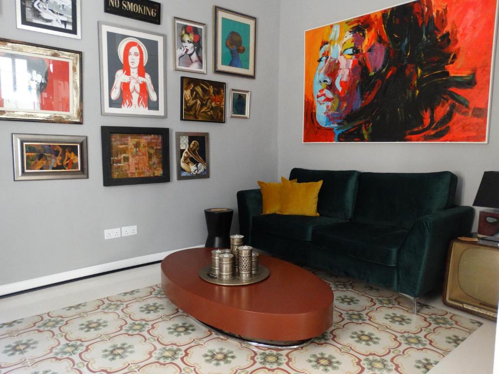 a living room with a green couch and a table at 60 Indri Borg Townhouse in Rabat