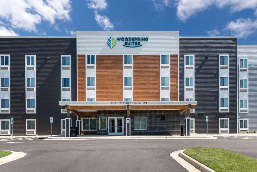 een gebouw met een bord aan de voorkant bij WoodSpring Suites Greensboro - High Point North in Greensboro