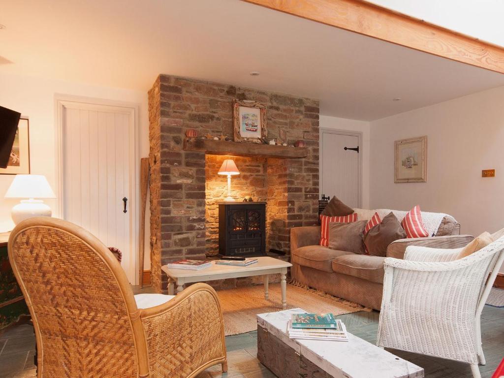 a living room with a couch and a fireplace at Shadycombe Lodge in Salcombe