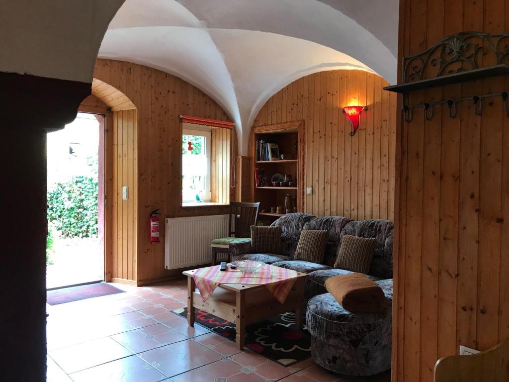 uma sala de estar com um sofá e uma mesa em Ferienwohnung Sunshine vom Friesenhof Wieratal 