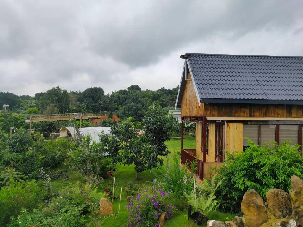ダラットにあるHoa Sơn Điền Viên Homestayの庭付き畑の木造家屋