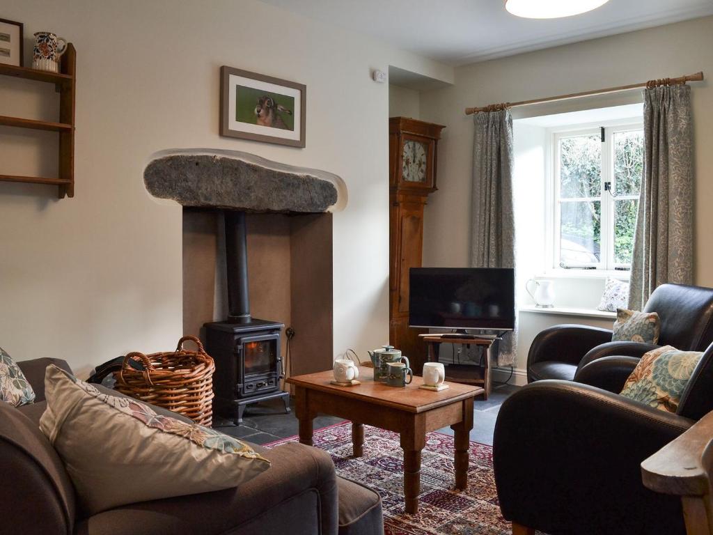 sala de estar con estufa de leña en Coopers Cottage, en Haverthwaite