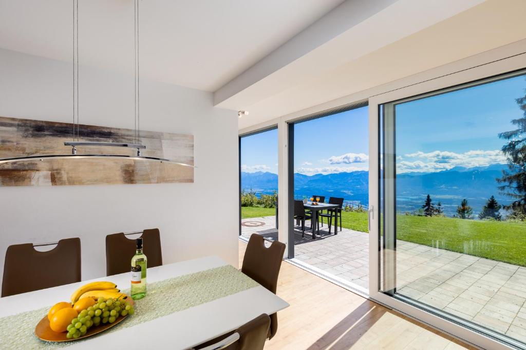 a kitchen and dining room with a view of the mountains at Gerlitzenzeit in Treffen