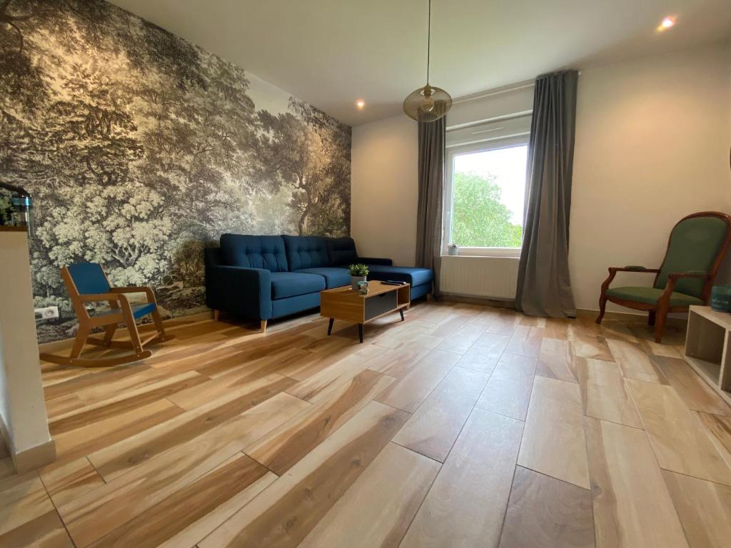 uma sala de estar com um sofá azul e pisos em madeira em Maison de ville au bord de l’eau (3) em Saint-Nicolas-de-Port