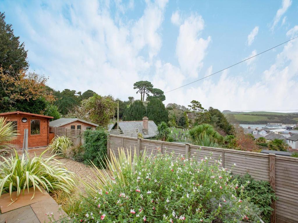 a garden with a wooden fence and plants at Oakridge in Salcombe