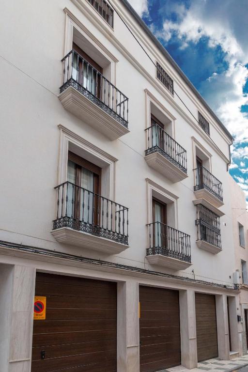 a white building with two garage doors and balconies at Villa Viana in Rute