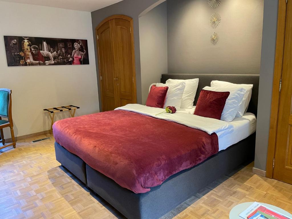 1 dormitorio con 1 cama grande con manta roja en B&B Monroe, en Averbode