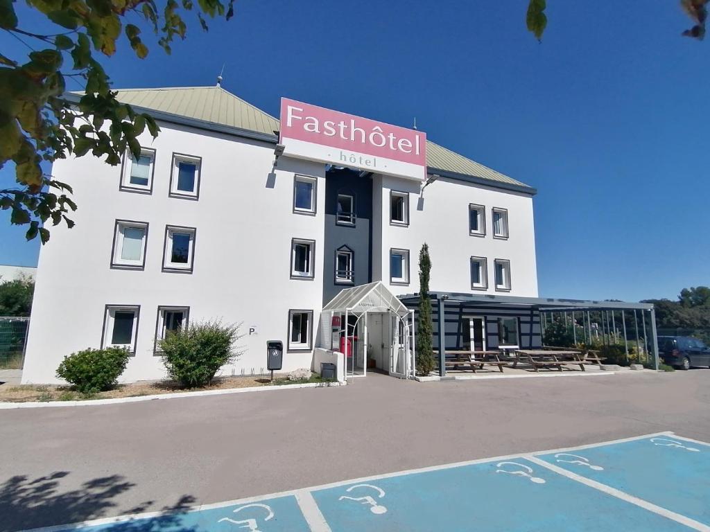 - un grand bâtiment blanc avec un panneau dans l'établissement FastHotel Montpellier Ouest - Un Hôtel FH Classic, à Saint-Jean-de-Védas