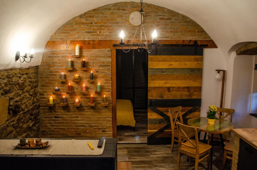 a room with a brick wall and a table with candles at Apartament 42.2 in Bistriţa