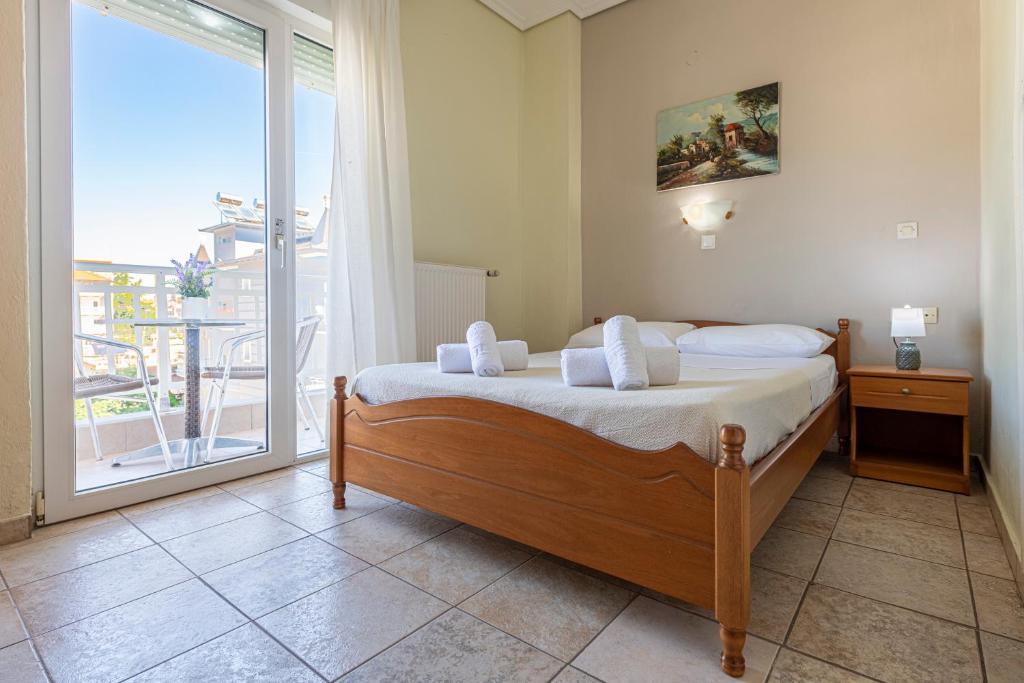 1 dormitorio con cama y ventana grande en Lucia Hotel Paralia en Paralia Katerinis