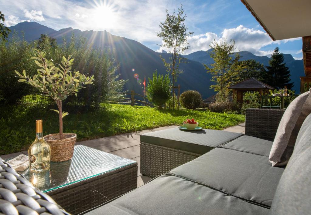 a patio with a table and a view of the mountains at Panoramapark Soleil B Garden Apartment in Wengen