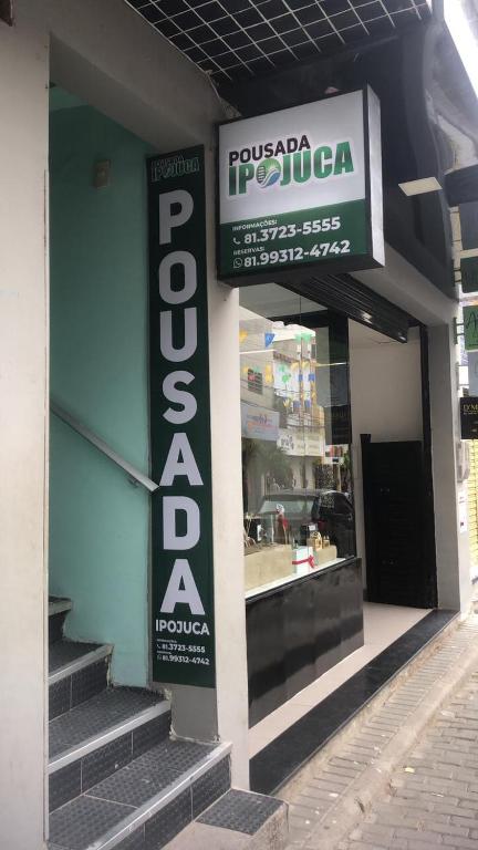 un magasin avec un panneau sur le côté d'un bâtiment dans l'établissement Pousada Ipojuca, à Caruaru