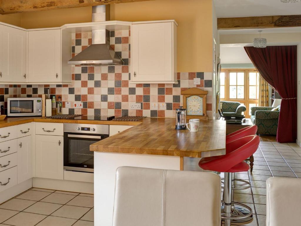 a kitchen with white cabinets and a counter top at Leonard Barn in Stonehouse