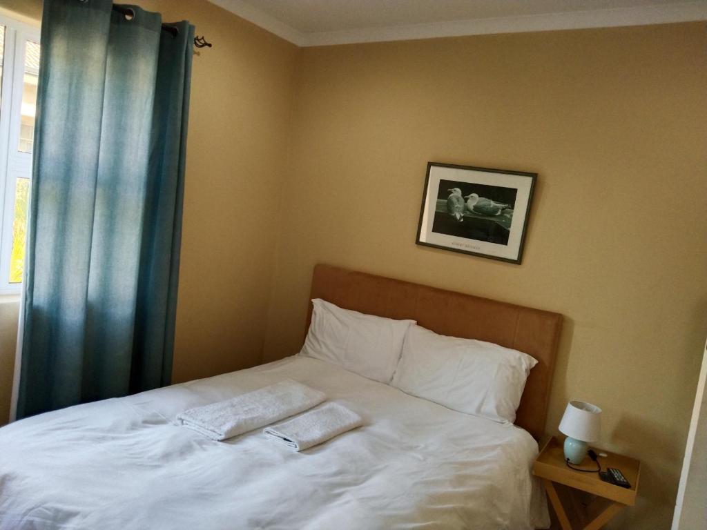 1 dormitorio con 1 cama con 2 toallas en On the Wrench, en Ciudad del Cabo