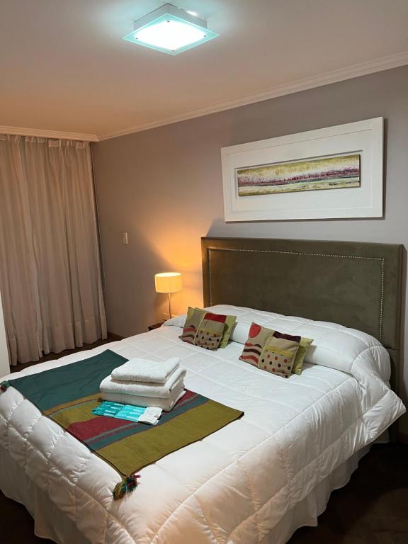 sypialnia z dużym białym łóżkiem z poduszkami w obiekcie Comfort Center Inn w Córdobie