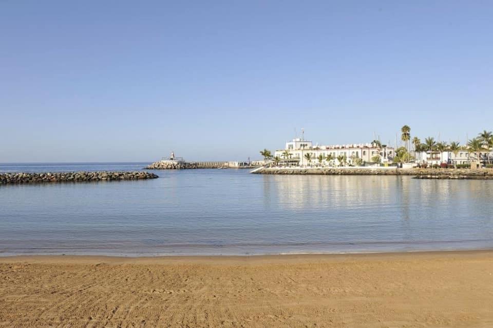 a view of a beach with houses in the background at Apartamento El Cercado Mogan in Mogán