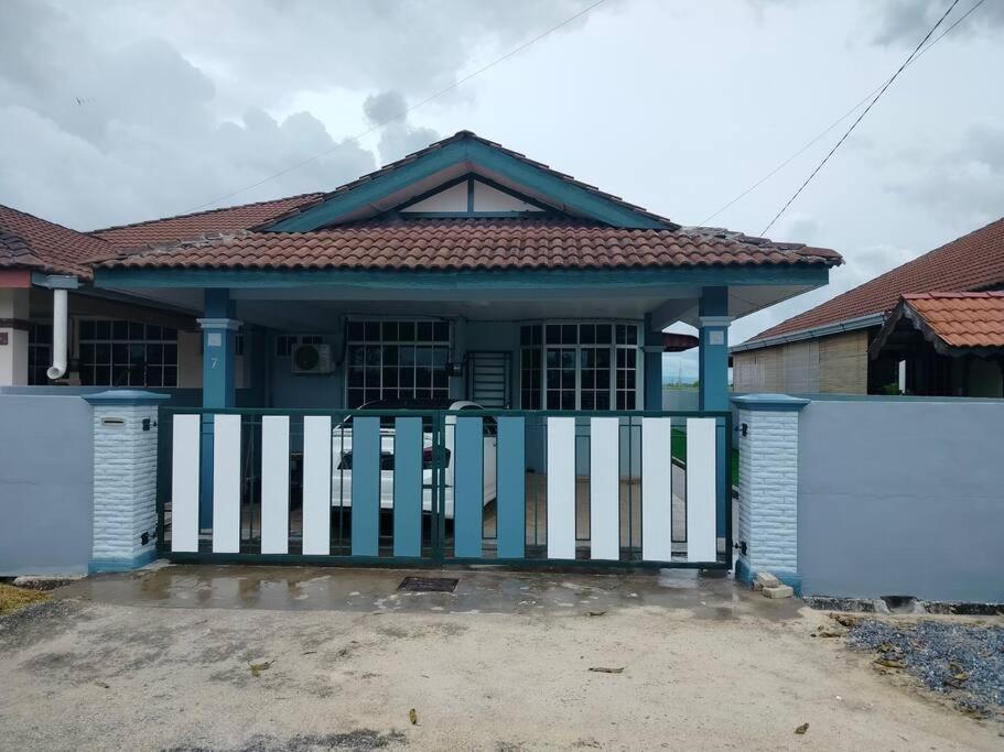 una casa con un cancello blu e bianco di MyHomestay07 a Kangar