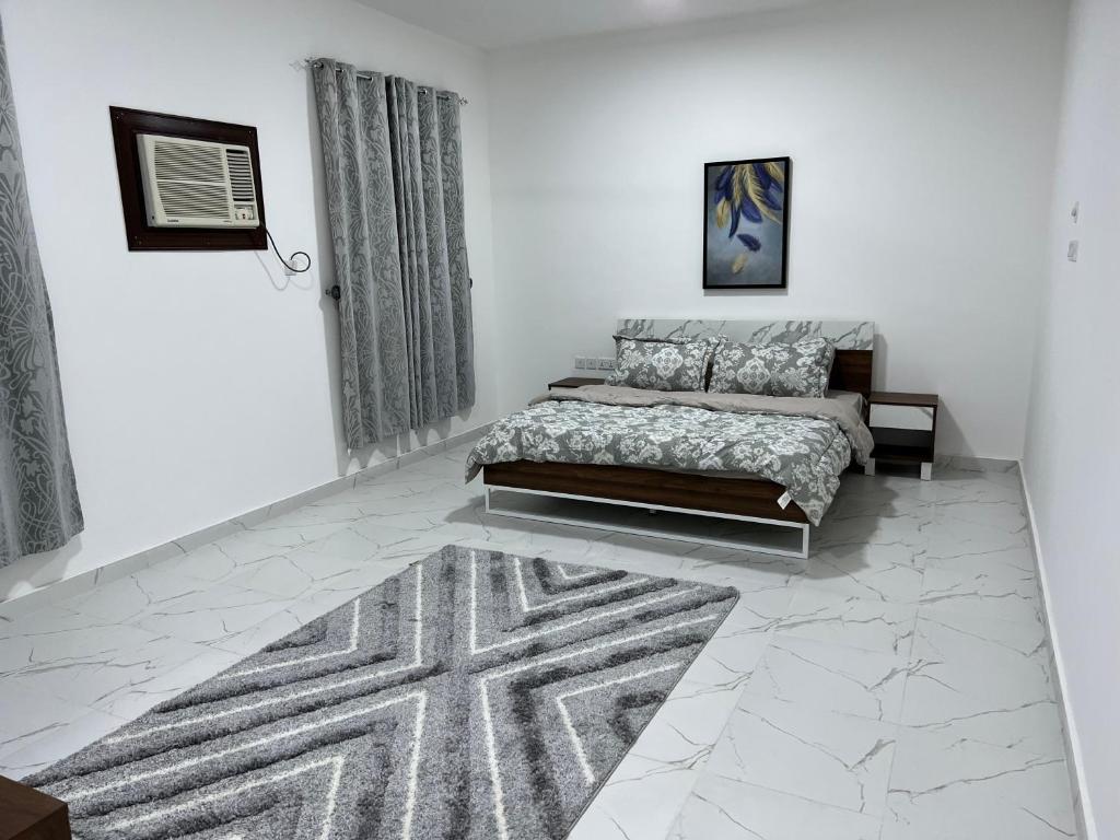 a bedroom with a bed and a rug at Al Shiya Chalet in Sur