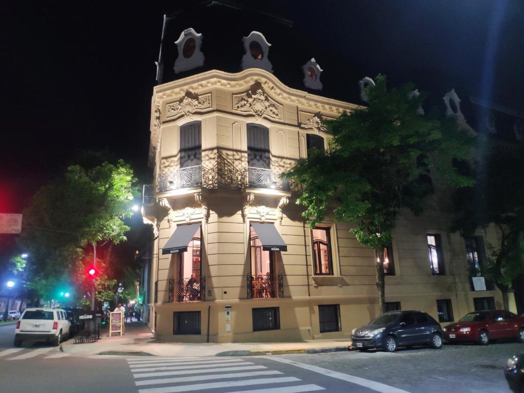 un grande edificio bianco con torre dell'orologio di notte di Departamentos Boulevard Caseros a Buenos Aires
