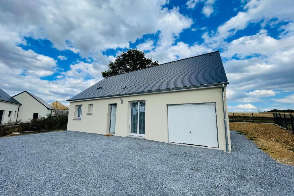 uma grande garagem branca com uma grande porta em Spacious modern house near the Golf of Ardrée em Saint-Antoine-du-Rocher