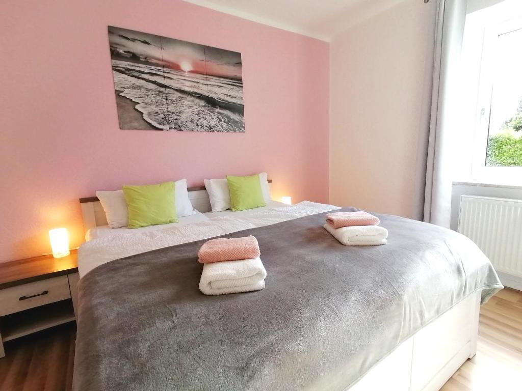 a bedroom with a large bed with towels on it at M-OASE Feeling Design I Küche I Netflix I Balkon in Braunschweig