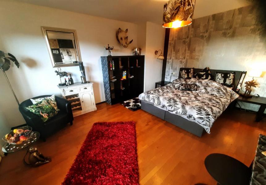 1 dormitorio con cama y alfombra roja en African Lodge im Pilgerglück, en Jüchen