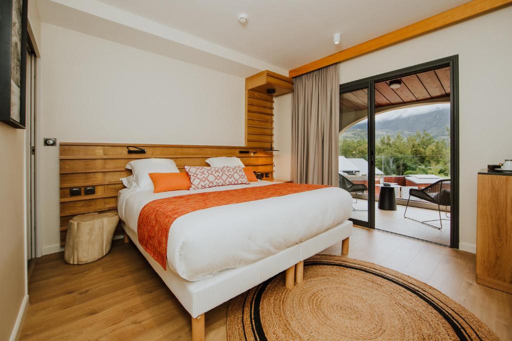 1 dormitorio con 1 cama grande y balcón en Sarana Hôtel & Spa en Salazie